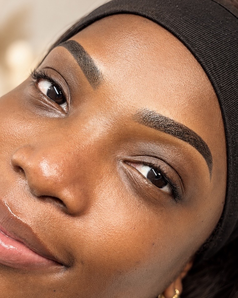 Close-up of precisely shaped eyebrows and elegant lashes, showing both brows